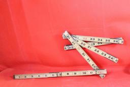 Two Craftsman old style folding rulers, one wood and one metal