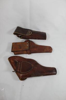 Three right handed leather holsters. One web belt flap and two belt holsters. Used.