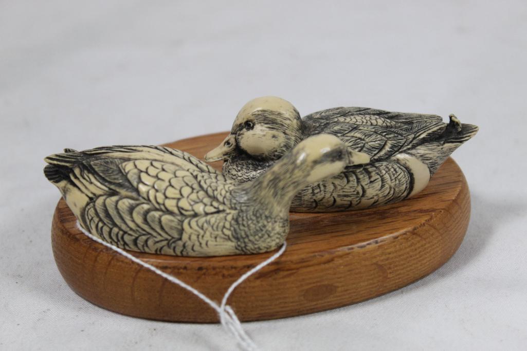 Small ceramic pair of ducks on wood.