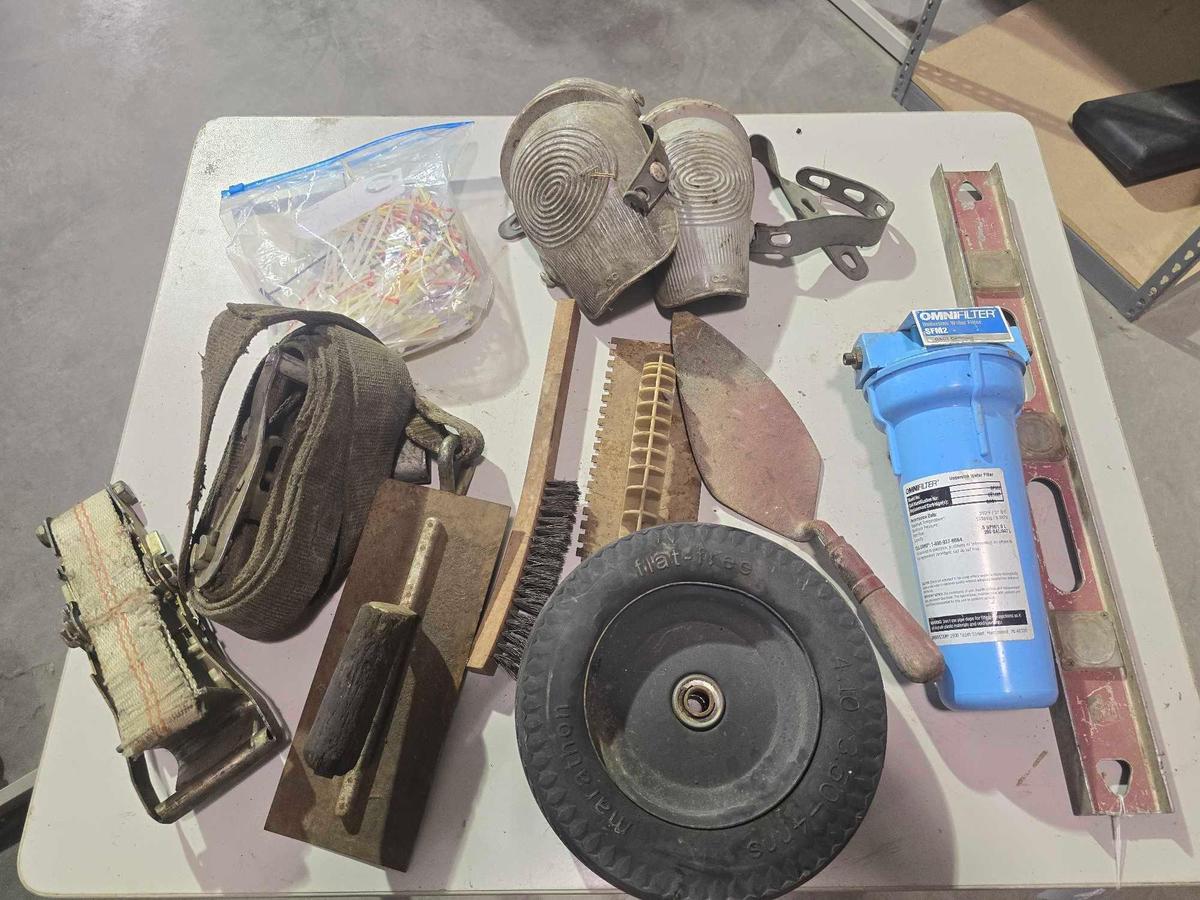 One ratchet strap, one ratchet without the straps, pair of knee pads three concrete trowels, water