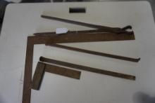 One framing square, small wood and metal square, blacksmith's tongs, and metal pry bar.