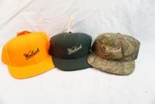 Three new Woolrich caps, one camo, one blaze orange and one hunter green