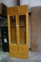 Oak 8 gun and 1 pistol gun case, with 3 drawers, glass front doors, and two overhead cabinets. 96"