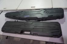 Two black hard plastic gun cases.