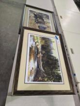 Two framed pictures. One of fly fisherman, and one Black Lab with Mallard.