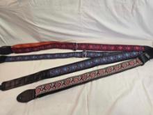 Four colorful cloth guitar straps.