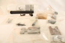 Bag containing an A2 buffer tube, muzzle break, unknown trigger assemblies, and other gun parts