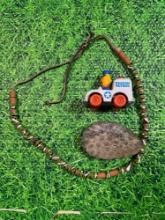 fossil rock, beaded necklace, and vintage sesame street toy
