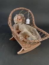 Wicker cradle with bisque doll, compo body