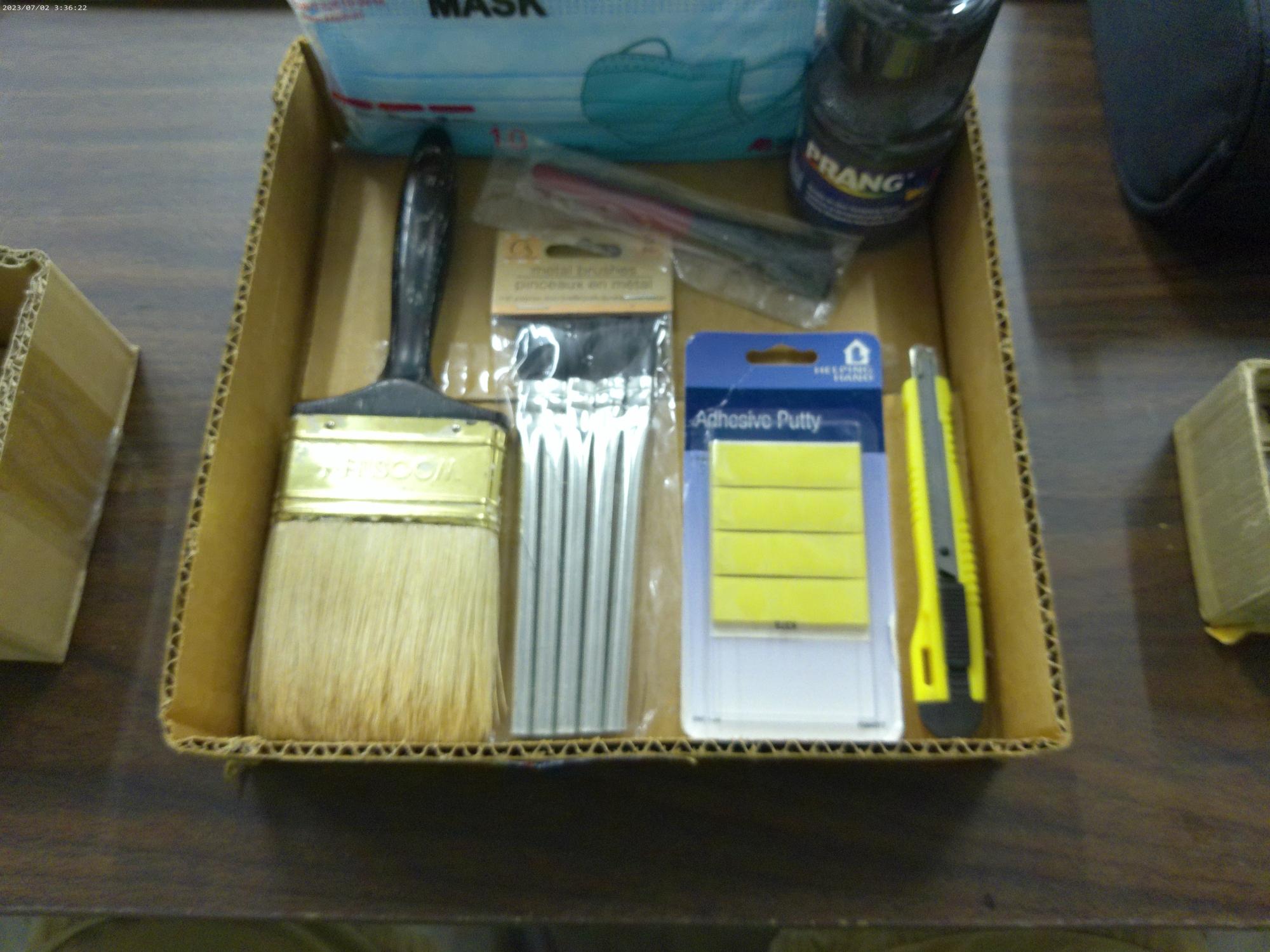 crafting lot, various paint brushes, box cutter, adhesive putty, bottle of black paint and a new pac
