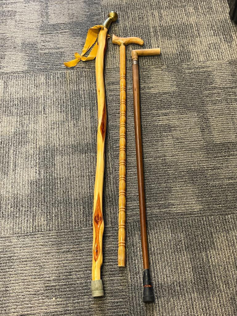 THREE WOOD WALKING STICKS INCLUDING ONE POLISHED PINE WITHG BRASS NOB HANDLE