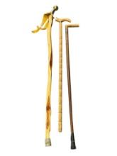 THREE WOOD WALKING STICKS INCLUDING ONE POLISHED PINE WITHG BRASS NOB HANDLE