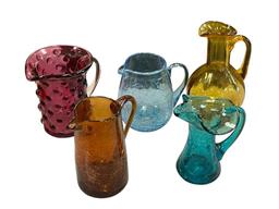 FIVE HAND BLOWN ART GLASS SMALL PITCHERS IN VARIOUS COLORS AND STYLES, RUFFLED RIM, CRACKLED GLASS
