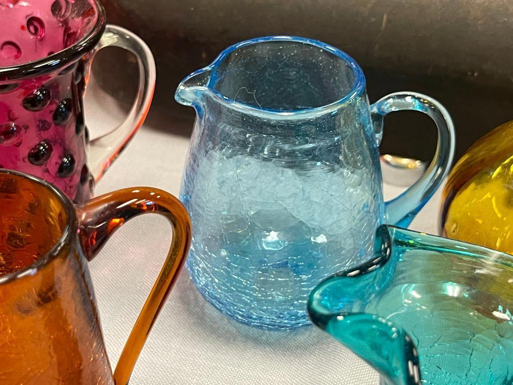 FIVE HAND BLOWN ART GLASS SMALL PITCHERS IN VARIOUS COLORS AND STYLES, RUFFLED RIM, CRACKLED GLASS