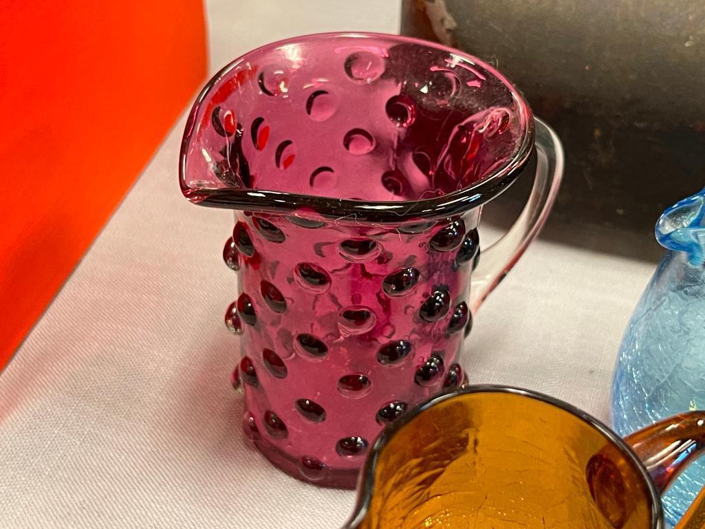 FIVE HAND BLOWN ART GLASS SMALL PITCHERS IN VARIOUS COLORS AND STYLES, RUFFLED RIM, CRACKLED GLASS