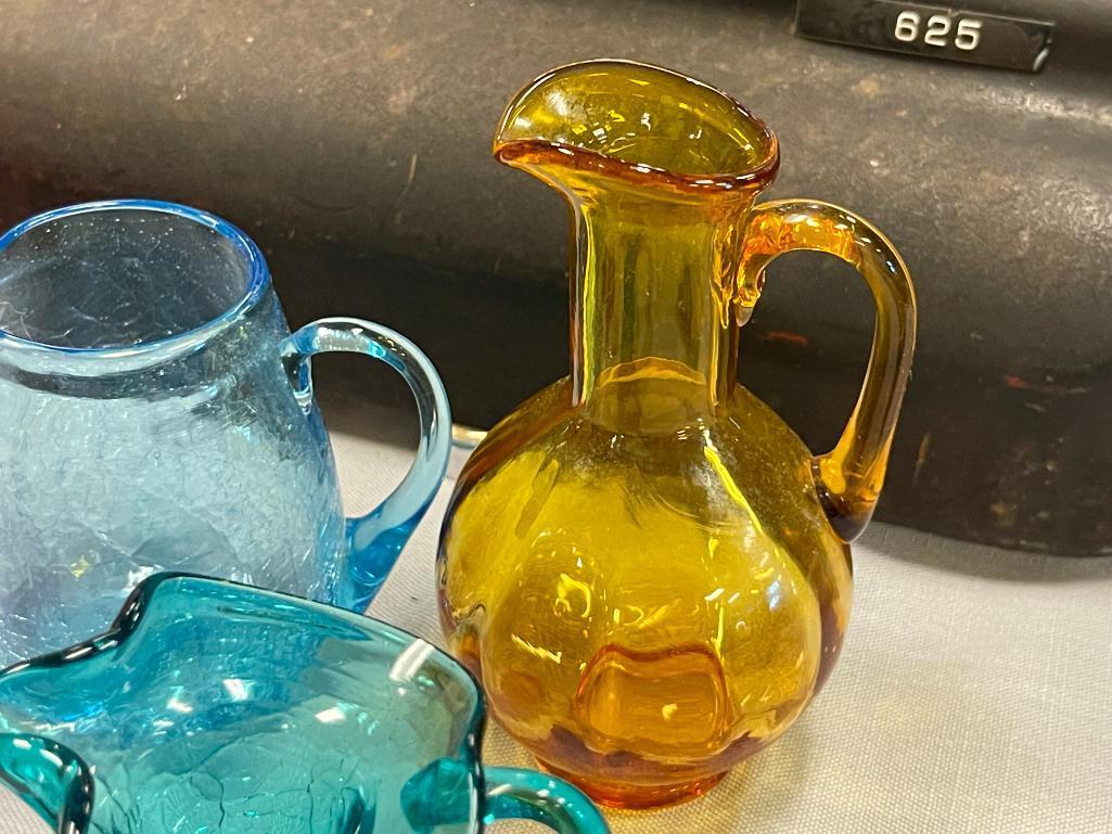 FIVE HAND BLOWN ART GLASS SMALL PITCHERS IN VARIOUS COLORS AND STYLES, RUFFLED RIM, CRACKLED GLASS