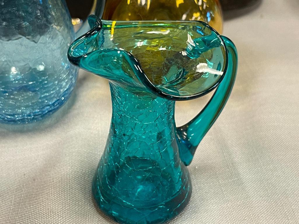 FIVE HAND BLOWN ART GLASS SMALL PITCHERS IN VARIOUS COLORS AND STYLES, RUFFLED RIM, CRACKLED GLASS