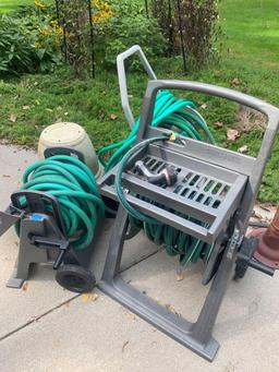 Three hose reel?s with hose and plastic planters