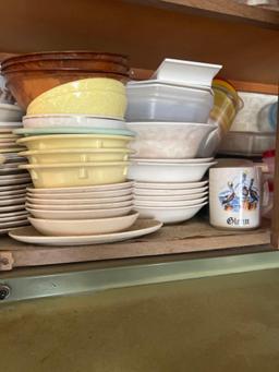Bottom shelf of kitchen cabinet some Corelle dishes and more