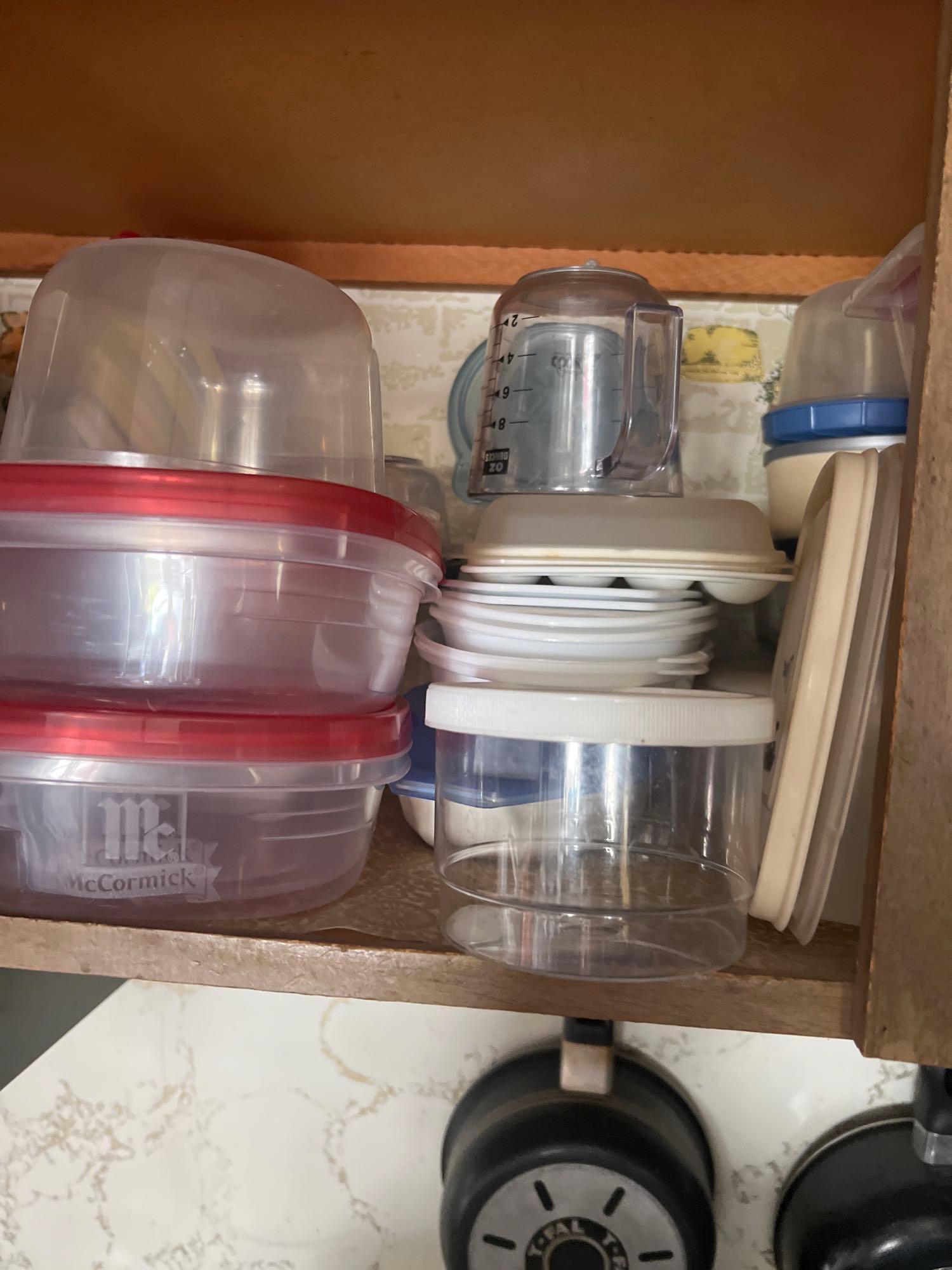 Bottom shelf of kitchen cabinet some Corelle dishes and more