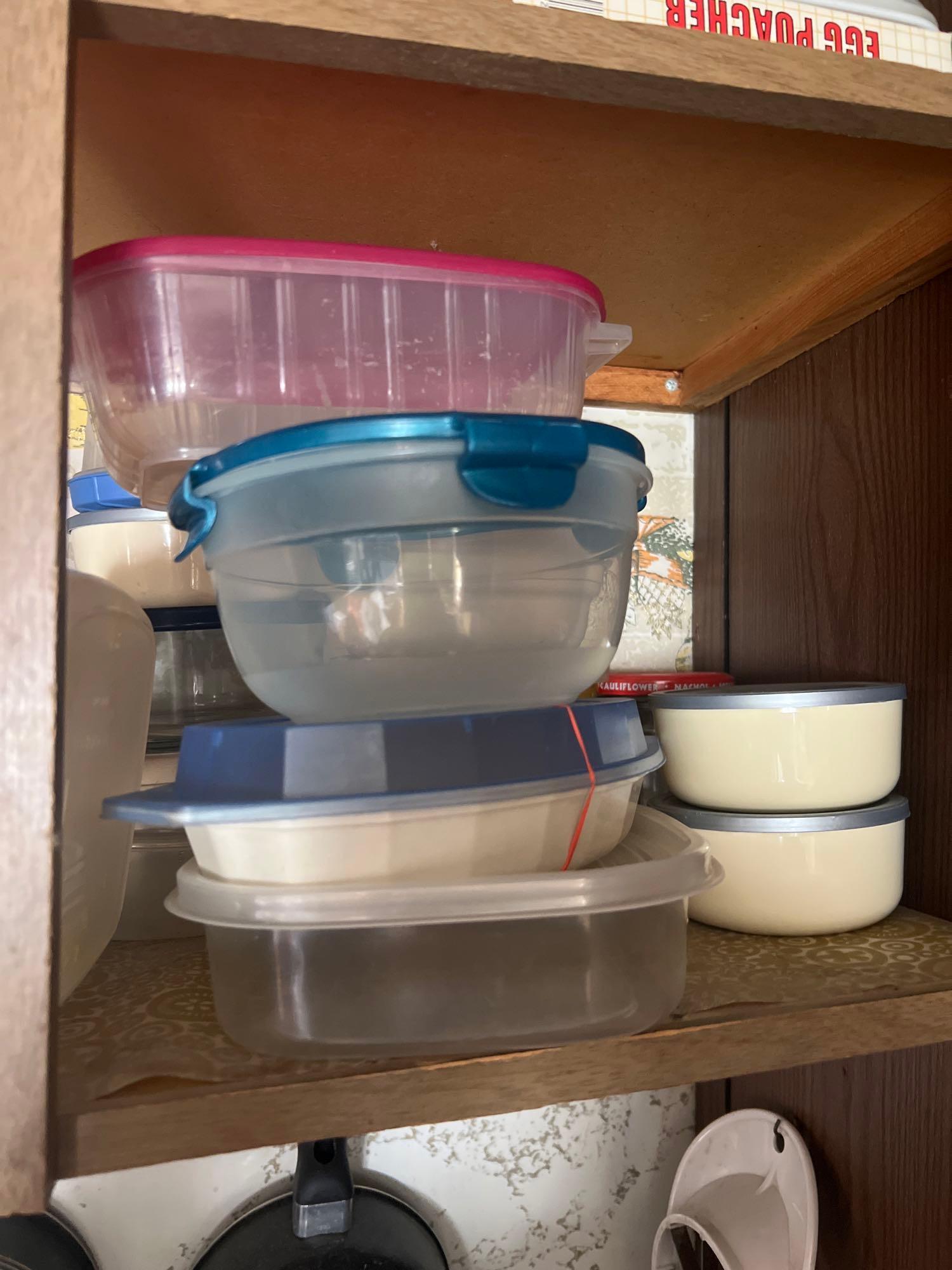 Bottom shelf of kitchen cabinet some Corelle dishes and more