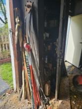Cabinet with contents in and around, including fishing poles