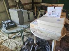 2 tables with contents, including luggage and wedding dresses.