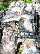 Approximately twenty bags of red lava rock