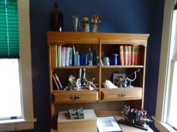 Items on shelves on top of bookcase. Walkie Talkies, Ansel Adams "Oak Tree" reproduction, bookends,