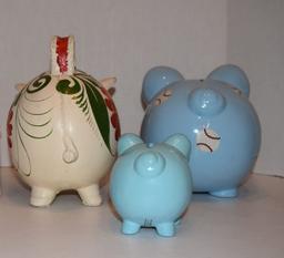 ceramic piggy banks one small blue one medium size blue with baseball design and one white piggy wit