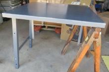 Steel industrial 36" x 30" work table extension with adjustable height folding legs on one end.