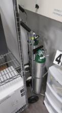 Oxygen tank carts with gauges and regulators.  Bottles appear to be rental units.