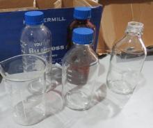 mixed glassware including chemical bottles, beakers, measuring ups