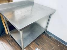 38 x 27" stainless steel table with stainless steel legs and under shelf table has a 4 inch backspla