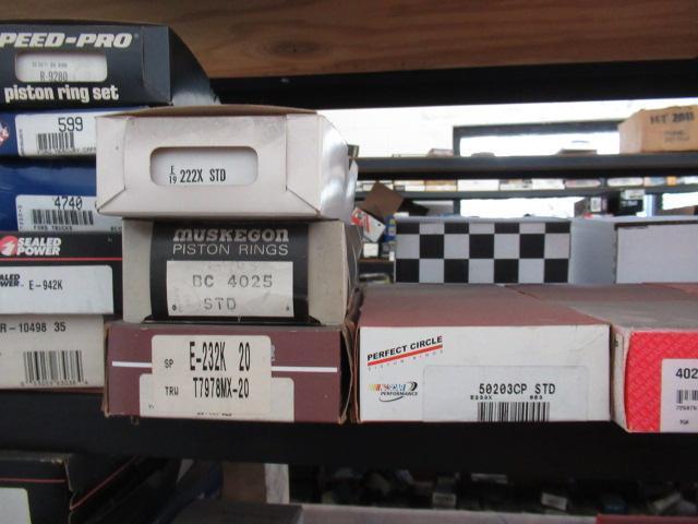 CONTENTS OF SHELF - ASSORTED HARMONIC BALANCERS, PISTON RING SETS, & OIL PUMPS