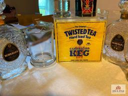 Four vintage liquor decanters, two glass beer pitchers, Twisted Tea bar display