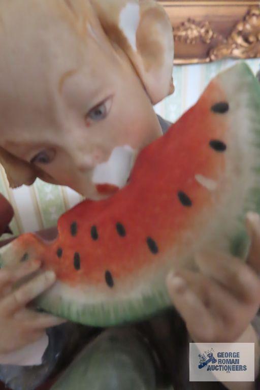 Hummel figurine and boy eating watermelon figurine, both have chips