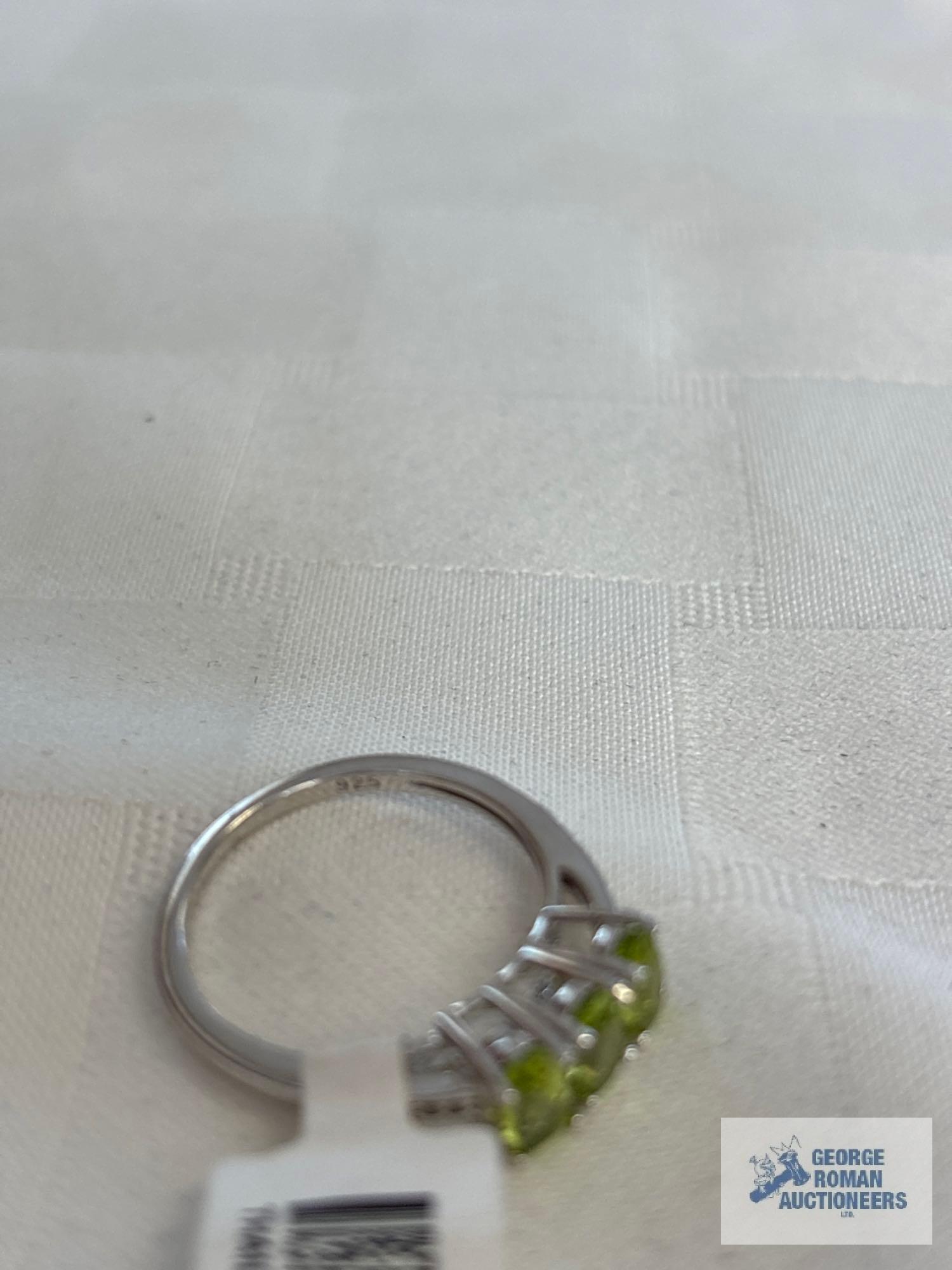 Silver colored ring with three pale green gemstones, marked 925, approximate total weight is 2.61 G