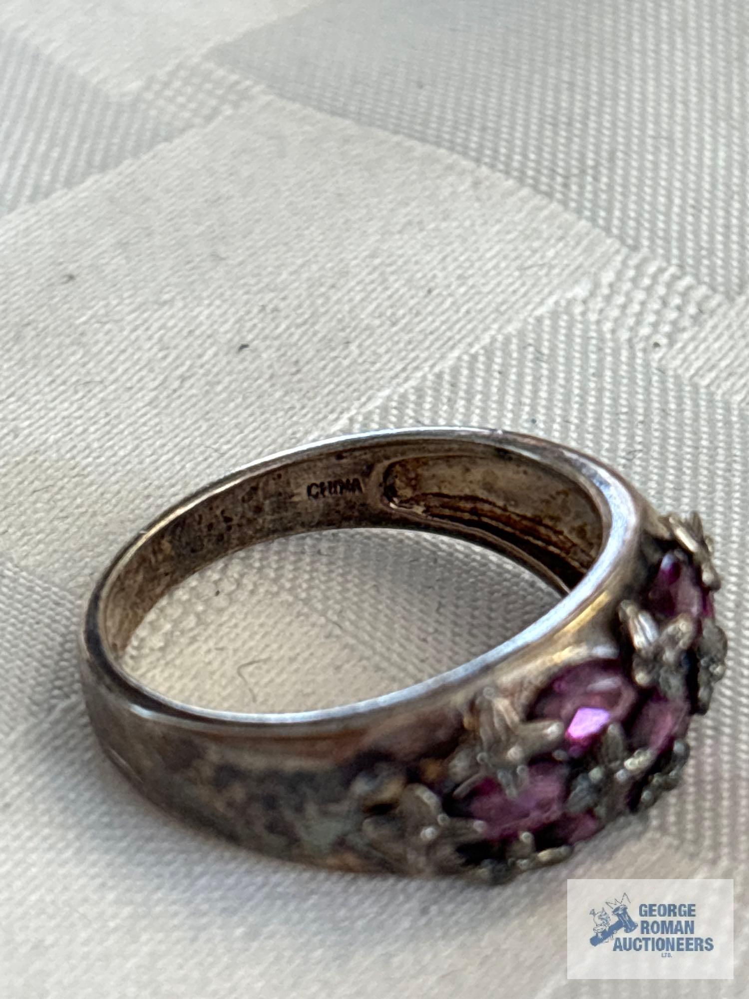 Silver colored ring with purple gemstones, marked 925, approximate total weight is 5.02 G
