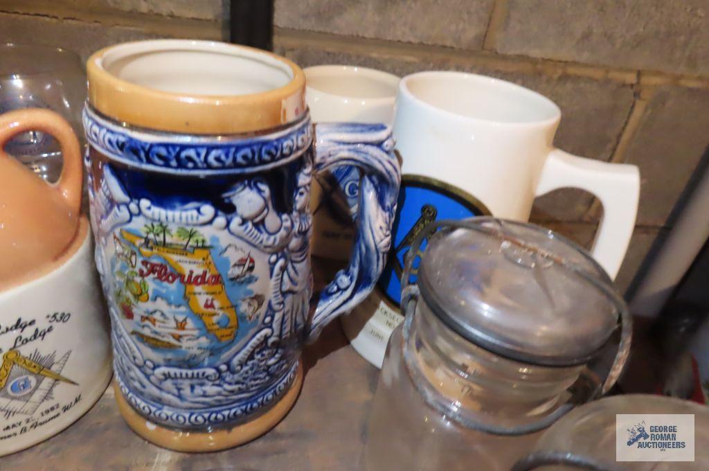 Assorted mugs, antique jars, and antique canning lids