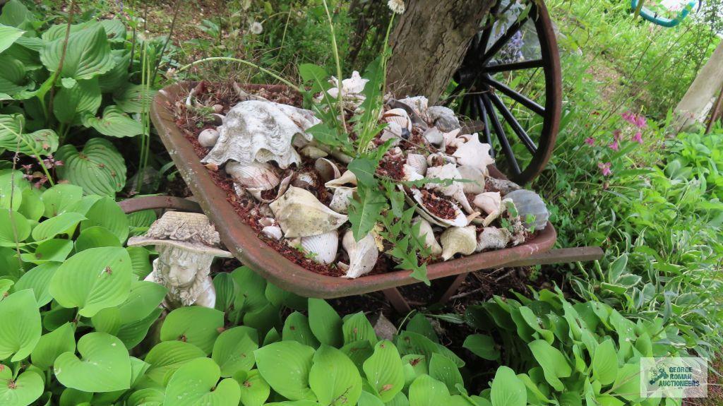 Metal wheelbarrow, wind chimes, girls sitting yard decoration, and seashells