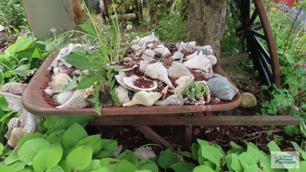 Metal wheelbarrow, wind chimes, girls sitting yard decoration, and seashells