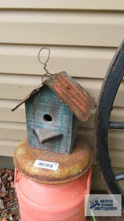 Orange milk can with birdhouse