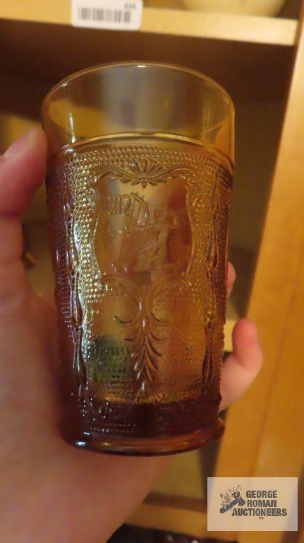 Amber colored glass bell, top hat, candle holder, and cup