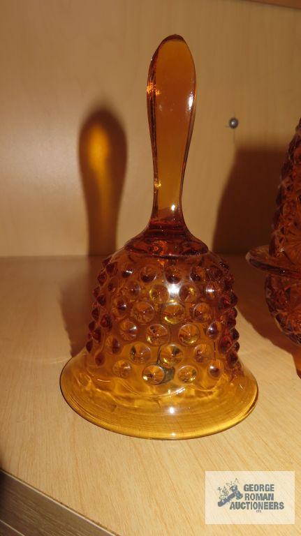 Amber colored glass bell, top hat, candle holder, and cup