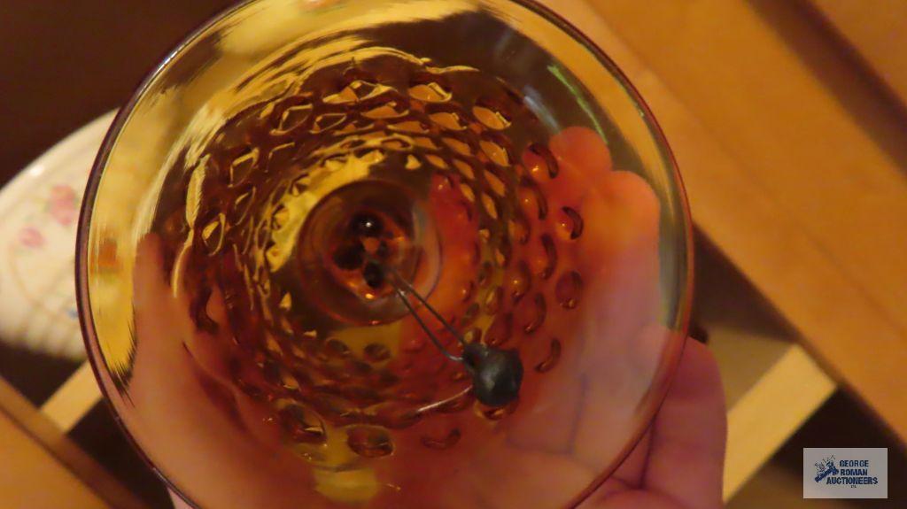 Amber colored glass bell, top hat, candle holder, and cup