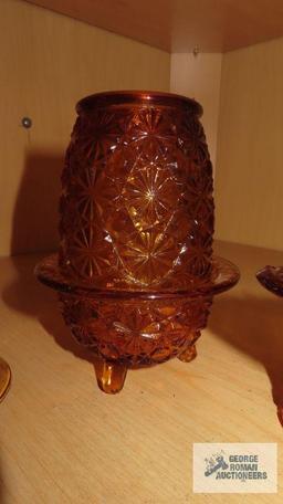 Amber colored glass bell, top hat, candle holder, and cup