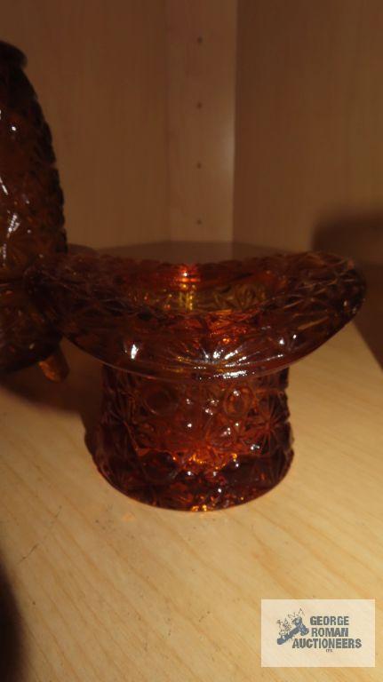 Amber colored glass bell, top hat, candle holder, and cup