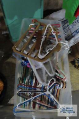 Two clothes racks and tote of hangers