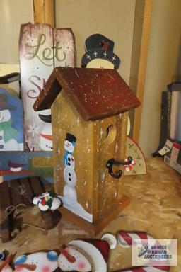 Christmas ornaments, snowman themed birdhouse, and other wooden decorations